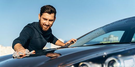 Mann putzt Auto