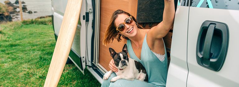 Eine junge Frau macht ein Selfie von sich und ihrem Hund in einem Wohnmobil