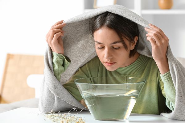 Junge Frau inhaliert wegen einer Erkältung