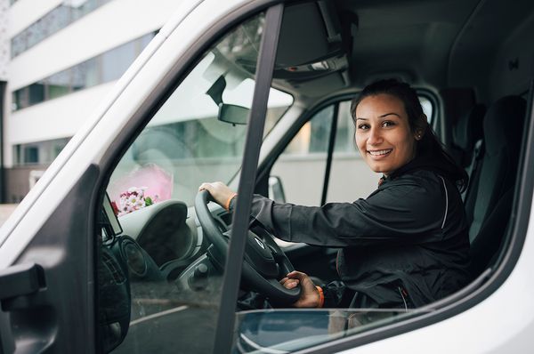 Junge frau fährt einen weißen Transporter