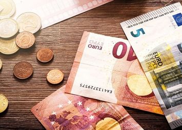 Geldscheine und Münzen auf einem Holztisch
