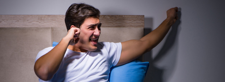 Mann trommelt gegen die Nachbarwand, wegen Lärmbelästigung