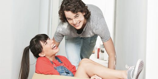 Frau und Mann lachen beim Umzugskarton packen. Wohnungswechsel - was passiert mit der Haushaltsversicherung?