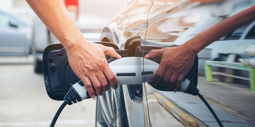 Person lädt Elektroauto auf Person lädt Elektroauto auf