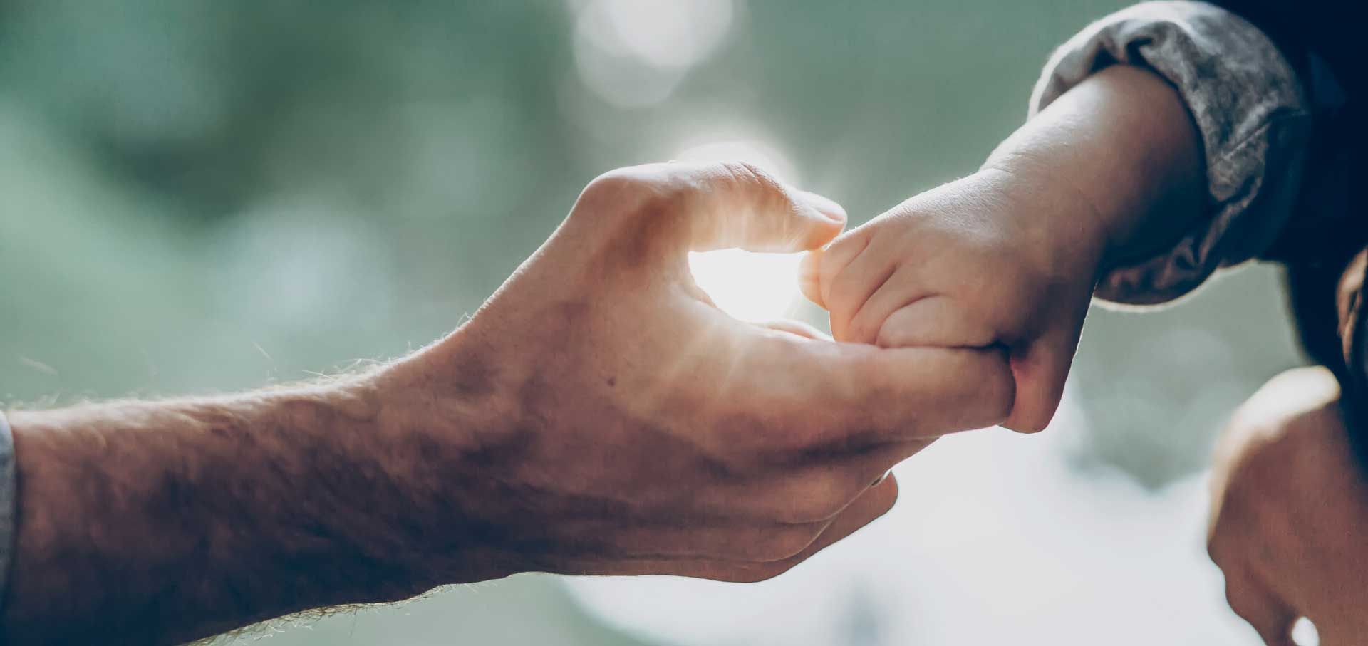 Hand von Baby hält Hand einer älteren Person