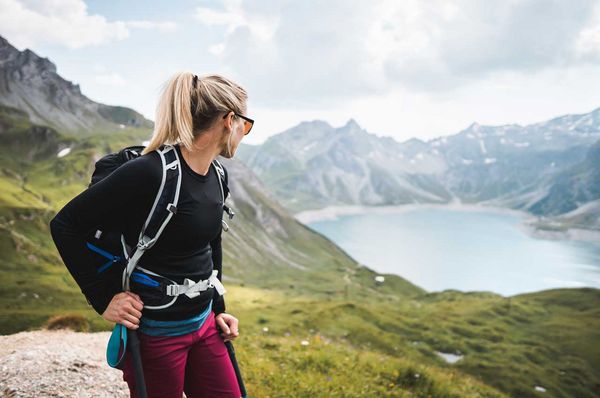 Junge Frau beim Wandern in den Bergen mit Blick auf einen See