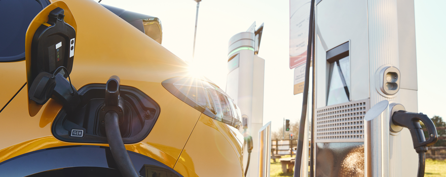 Gelbes Elektroauto wird an Ladestation aufgeladen Elektroauto wird an der Ladestation aufgeladen