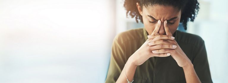 Frau stützt sich verzweifelt den Kopf nach ihrer Kündigung