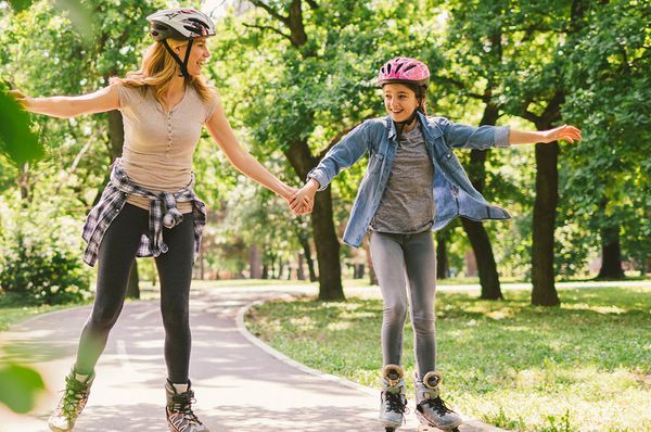 Unfallversicherung schützt bei Freizeitunfällen Mutter und Tochter beim Inlineskaten im Park