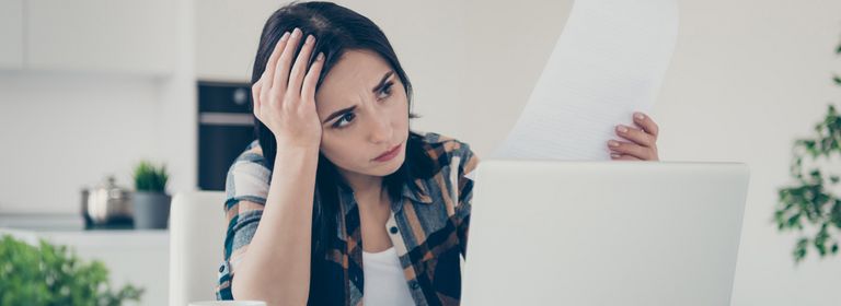 Junge Frau liest sorgenvoll eine Abmahnung.