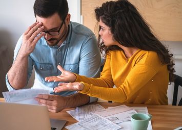 Mann und Frau sitzen am Tisch und diskutieren über Erbstreitigkeiten
