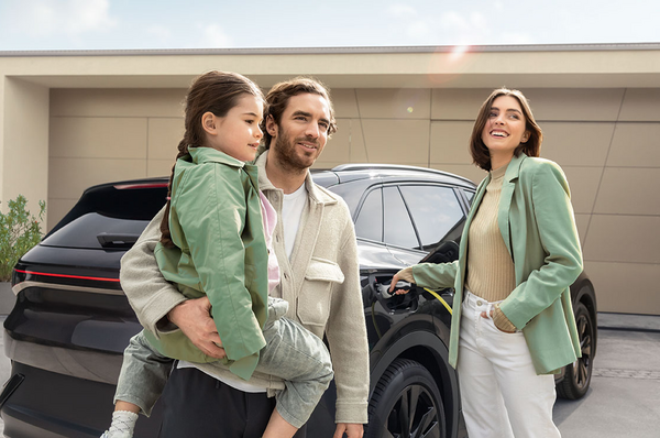 Familie steht vor schwarzem Elektroauto