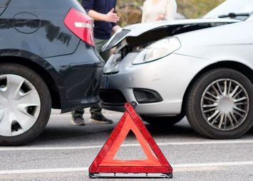 Warndreieck, das vor zwei Autos nach einem Auffahrunfall steht