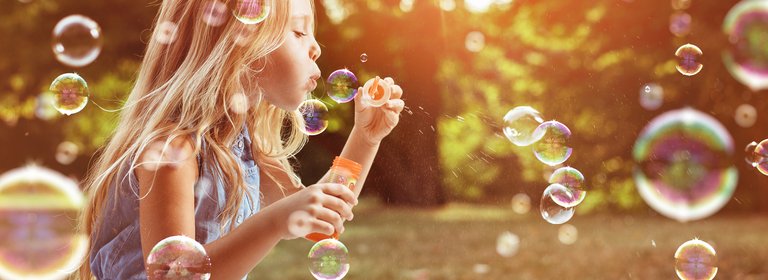 Kindervorsorge Schulanfang Ein Mädchen bläst Seifenblasen