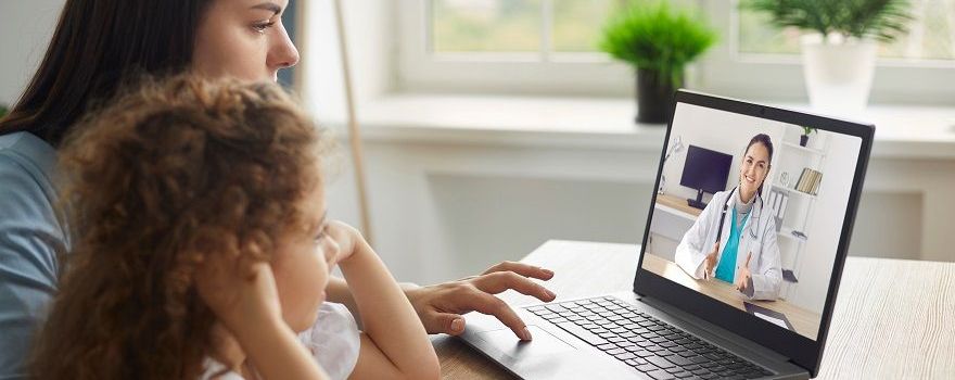 Mutter nutzt mit krankem Kind Telemedizin und telefoniert per Video-Telefonie mit einer Ärztin