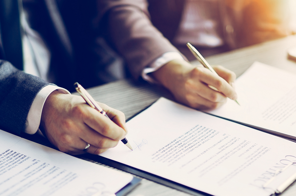 Person unterzeichnet einen Vertrag