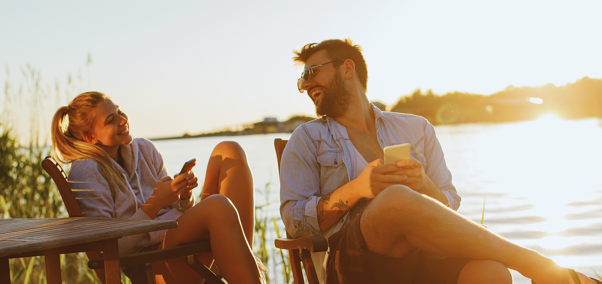 Pärchen sitzt am See bei Sonnenuntergang